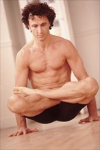 Man doing yoga pose. Photographer: Rob Lewine