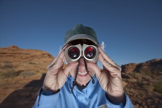 Elderly woman looking through binoculars. Photographer: Dan Bannister