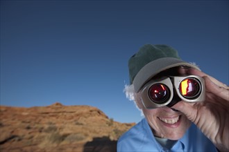 Elderly woman looking through binoculars. Photographer: Dan Bannister