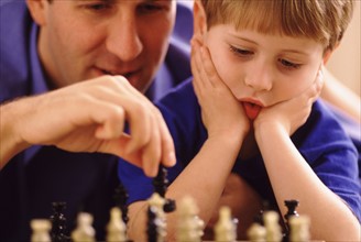 Father and son playing chess. Photographer: Rob Lewine