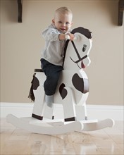 Baby on rocking horse. Photographer: Mike Kemp