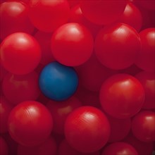 One blue ball amongst many red balls. Photographer: Mike Kemp