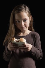 Young girl eating a sandwich. Photographer: Mike Kemp