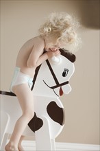 Toddler on rocking horse. Photographer: Mike Kemp