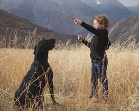 Girl playing fetch with dog. Photographer: Mike Kemp