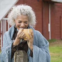Woman holding mug outside. Photographer: Pauline St.Denis
