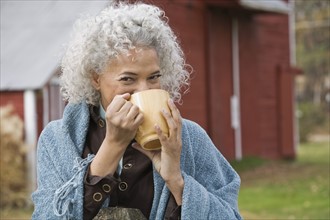Woman drinking from mug. Photographer: Pauline St.Denis