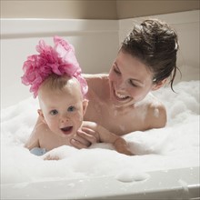Mother and child having bubble bath. Photographer: Mike Kemp