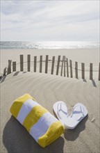 Towel and flip flops on the beach. Photographer: Chris Hackett