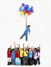 Boy floating away with balloons. Photographer: momentimages