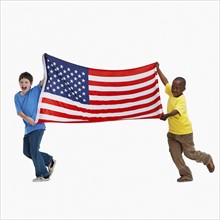 Two boys carrying American flag. Photographer: momentimages