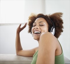 Woman listening to music on headphones. Photographer: momentimages