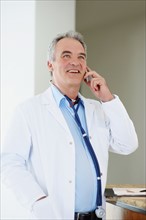 Doctor talking on phone. Photographer: momentimages