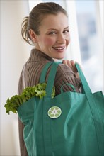Woman carrying bag of groceries.