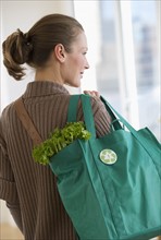 Woman carrying bag of groceries.