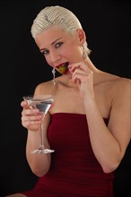 Woman drinking martini. Photographer: Daniel Grill