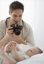 Father taking photograph of baby.