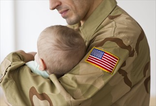 Soldier holding baby.