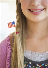 Young girl with American flag in hair.