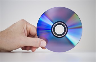 Hand holding compact disc.