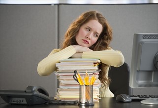 Overworked woman in cubicle.