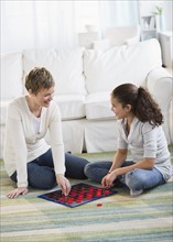 Mother and daughter playing checkers.