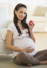 Pregnant woman eating an apple.