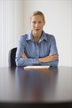Businesswoman sitting at conference table.