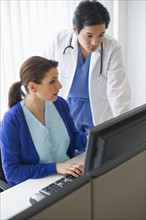 Doctor and nurse looking at computer.