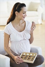 Pregnant woman eating chocolate.