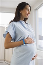 Pregnant woman wearing hospital gown.