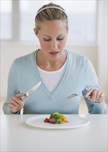 Woman eating small portion of food.
