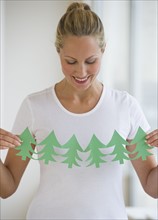 Woman holding cut out of trees.