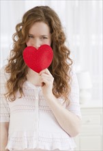 Woman holding a red heart.