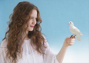 Woman with a dove perched on her hand.