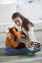 Young girl playing guitar.
