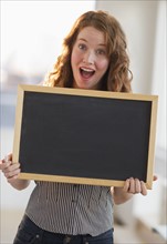 Woman holding a blank chalkboard.
