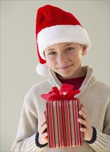 Young boy holding a Christmas present.