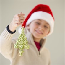 Young boy holding a Christmas ornament.
