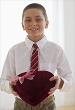 Young boy holding a box of chocolates.