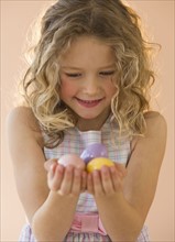 Young girl holding Easter eggs.