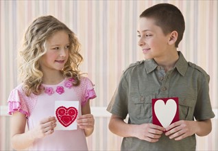 Young children holding Valentine cards.