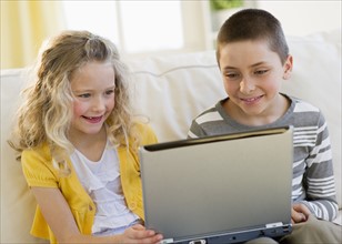 Young children looking at laptop.