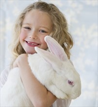 Young girl holding a rabbit.