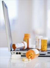 Bottles of prescription pills on laptop. Photographe : Jamie Grill