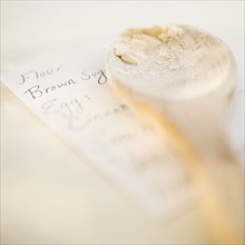 Wooden spoon on top of shopping list. Photographe : Jamie Grill