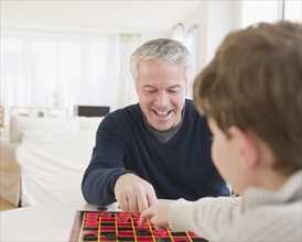Father and son playing checkers. Photographe : Jamie Grill