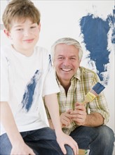 Father and son painting wall. Photographe : Jamie Grill