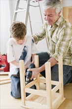 Father and son repairing stool. Photographe : Jamie Grill