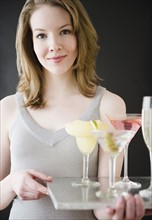 Woman holding tray of cocktails. Photographe : Jamie Grill